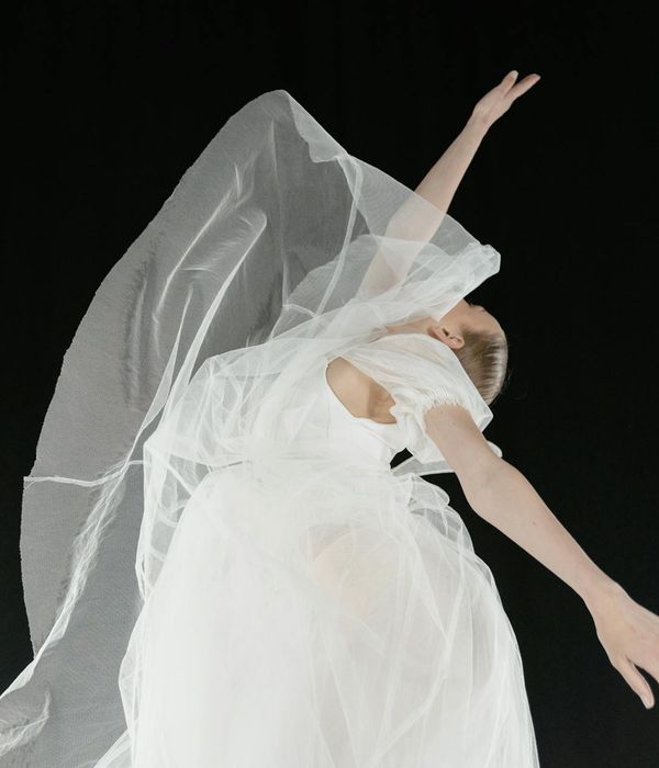 Woman performing a fluid yoga pose in a light, airy room.